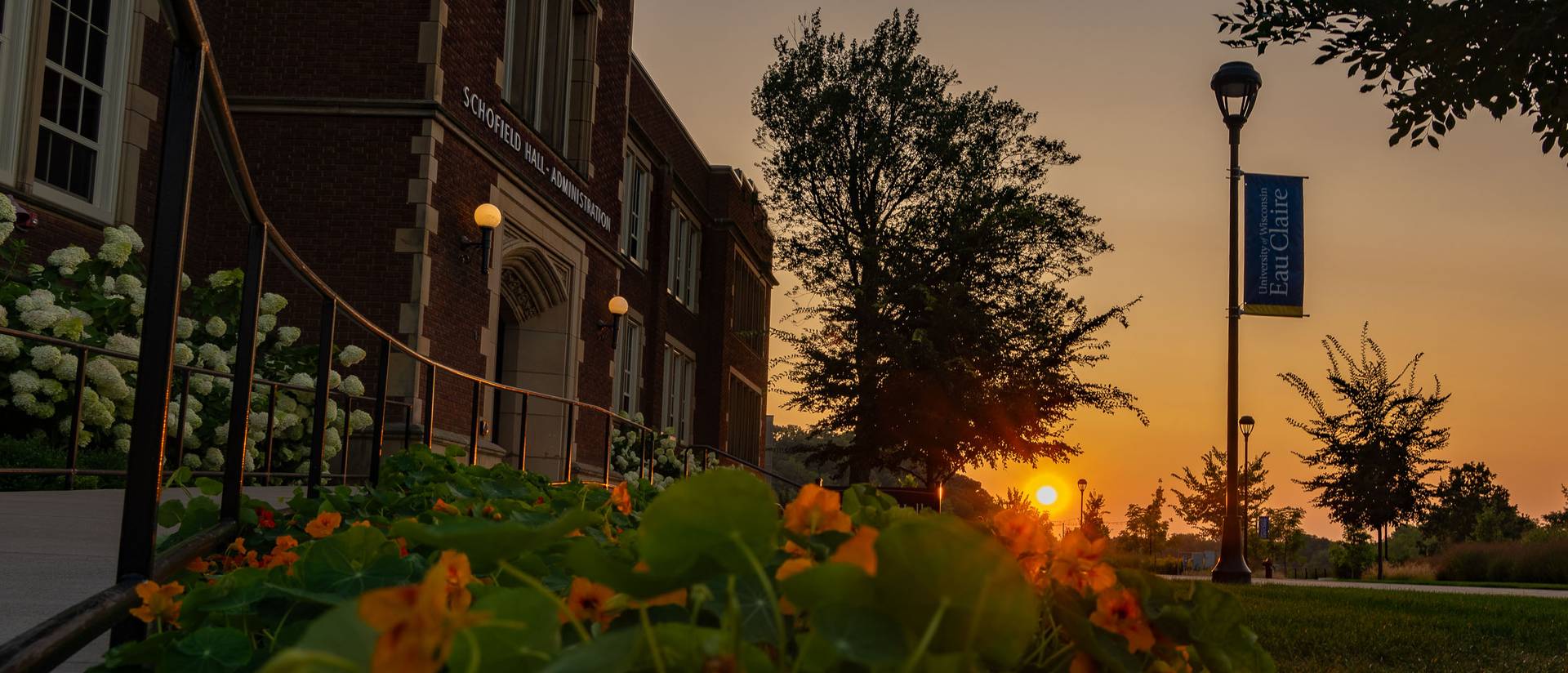 sunset over summer flower pot in front of Schofield Hall