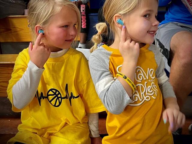 young girls at a Blugold basketball game testing ear plugs
