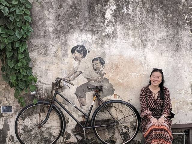 Profesor Kong in front of a mural in Malaysia.