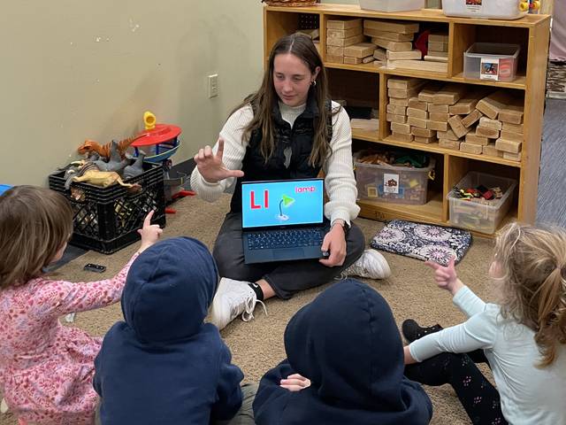 Kyra Saylor, CSD major, teaching sign language to young kids at the Children's Nature Academy