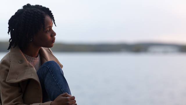 Contemplative person near lake.