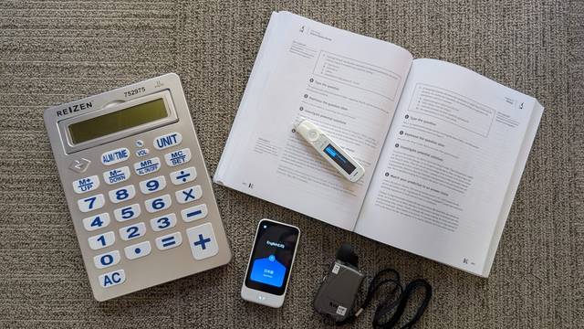 A talking calculator, text-to speech pen, pocket amplifier and a translator all arranged on a table.