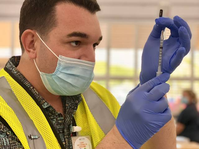 Jacob Schafer administering COVID vaccine