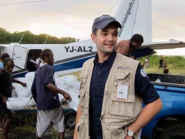 Humanitarian aide crew near an airplane delivering supplies