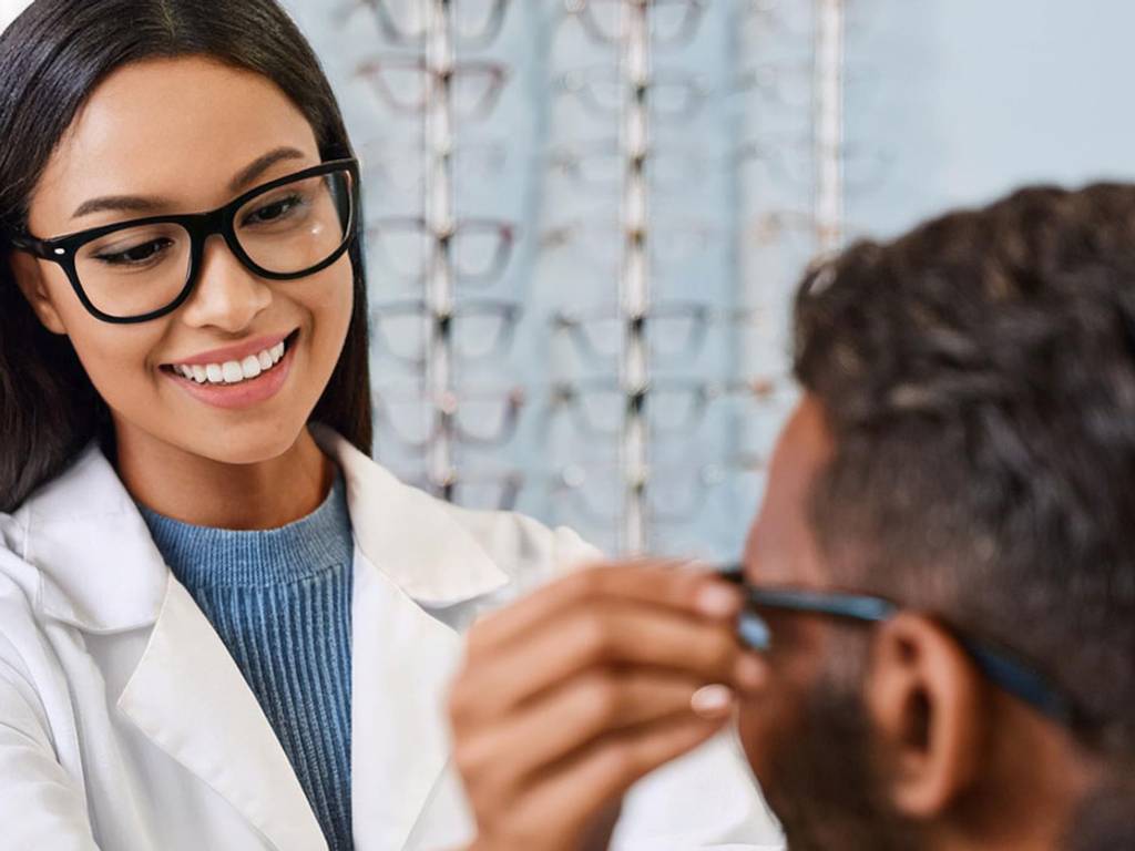 An optician giving a patient glasses.