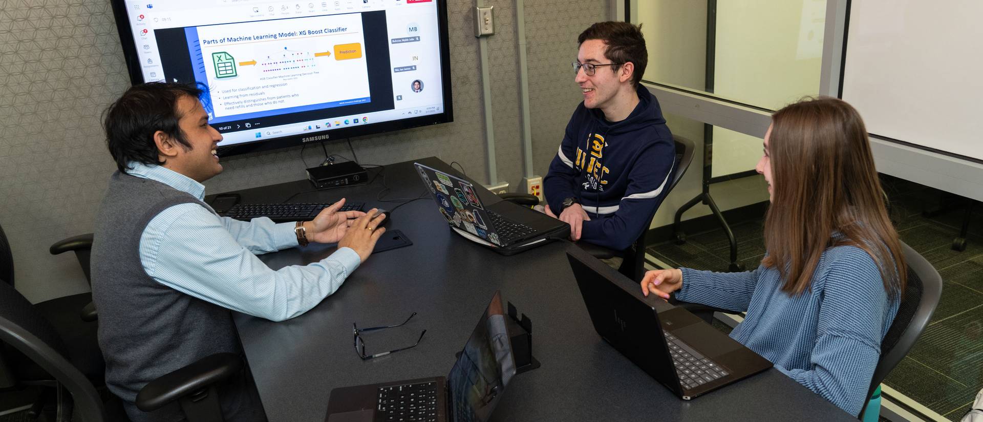 UW-Eau Claire faculty member and two students meeting