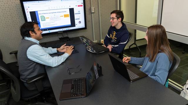 UW-Eau Claire faculty member and two students meeting