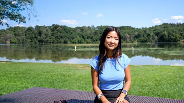 alumna Jenny Anderson sitting outside by a lake