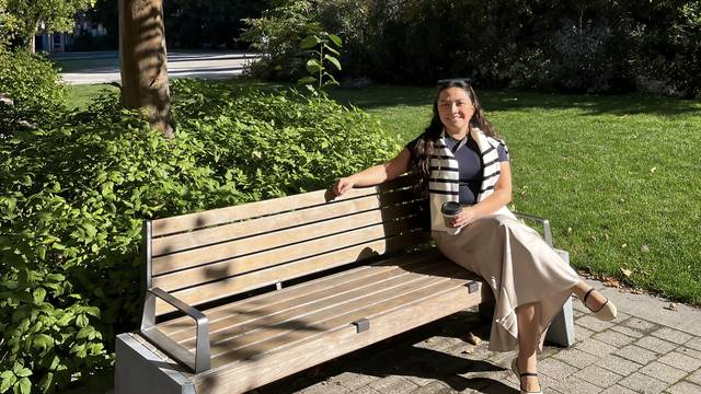 Helue Leslie-Vazquez sitting on a bench outdoors