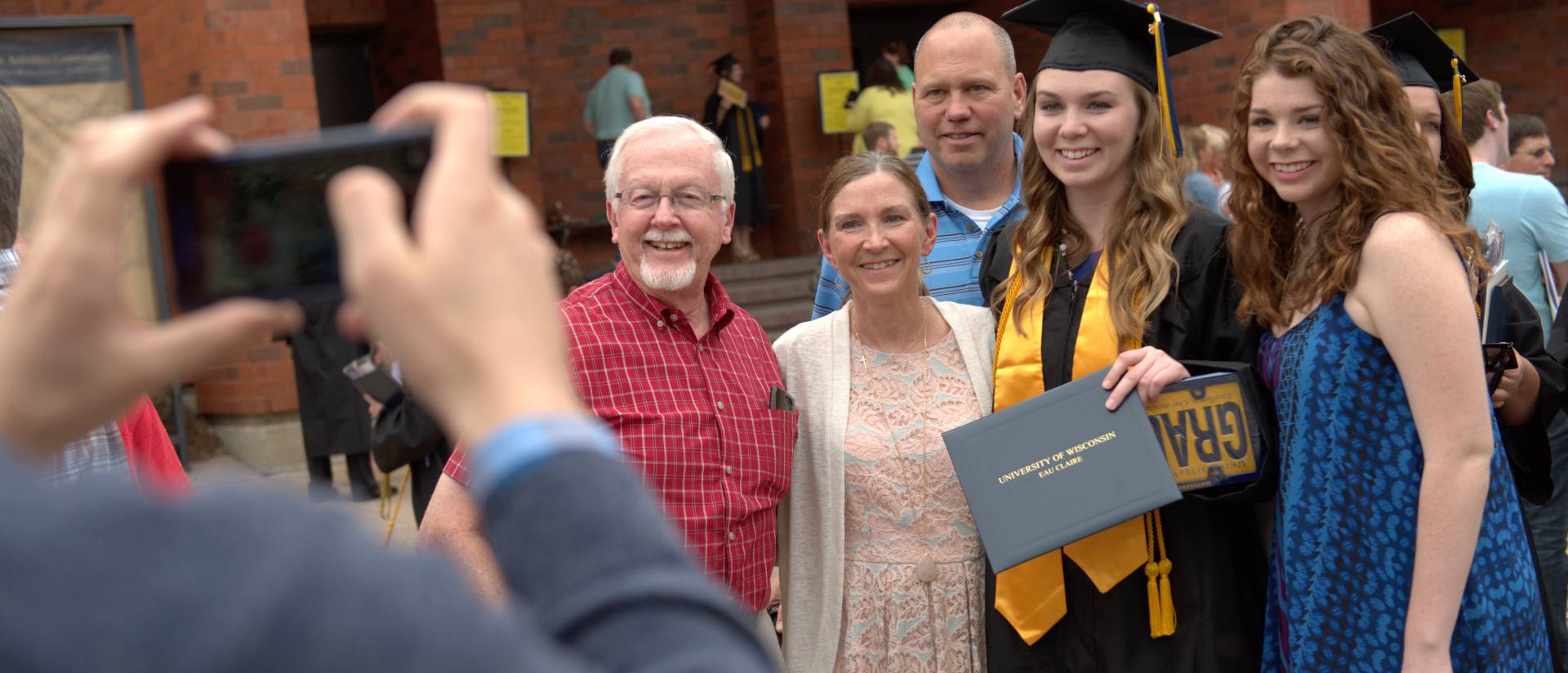 A family poses to celebrate their newest graduate.