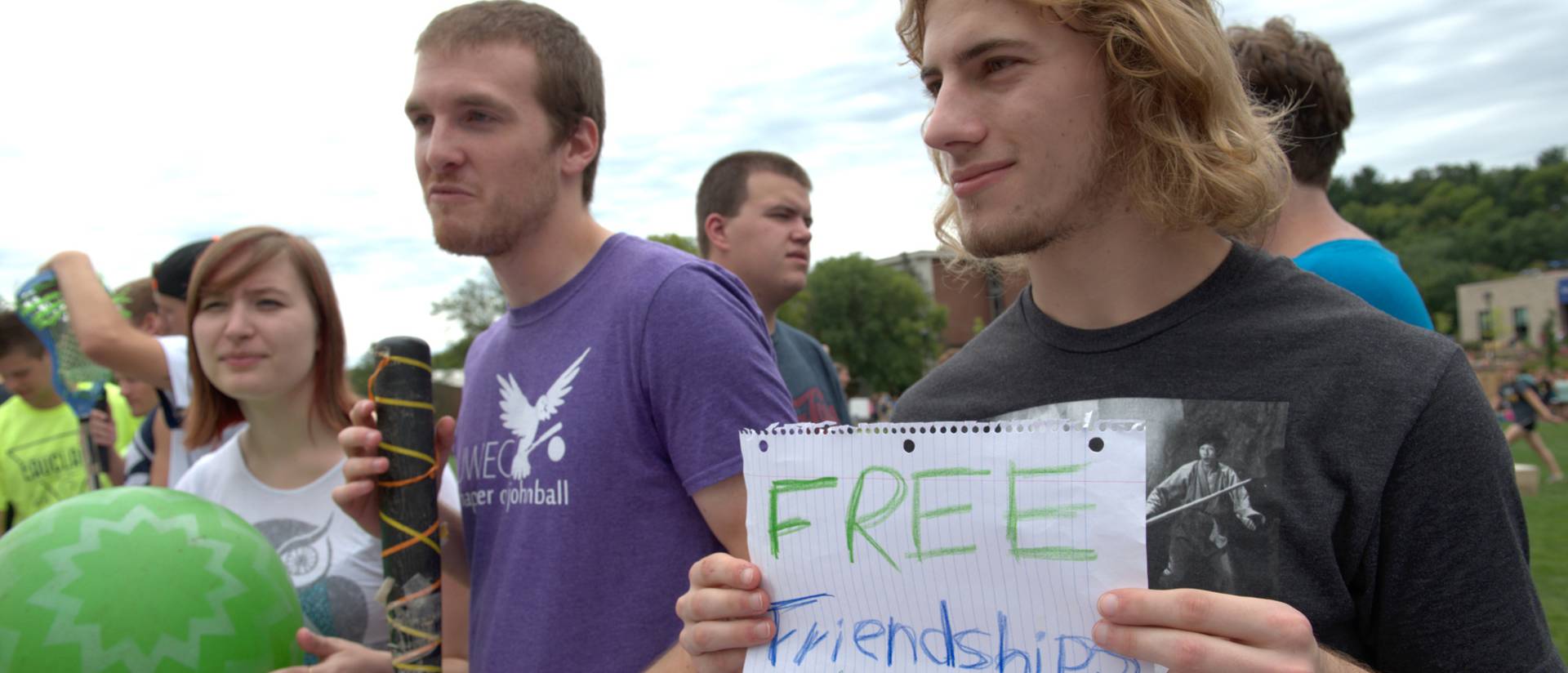 Three students recruiting for their student organization with a "Free friendships" sign.
