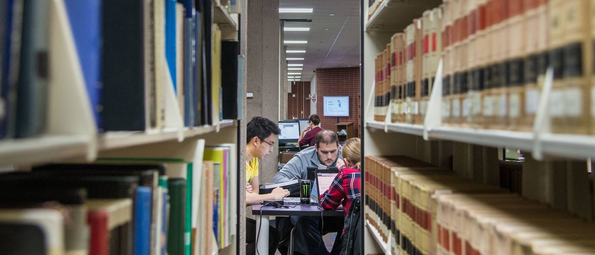 Three students studying in the library