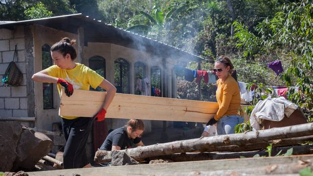 Blugolds Alyson Reum, left, and Ali Olmstead carry the lumber used to construct the walls for a new family home.