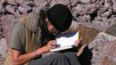 Student studying on rock