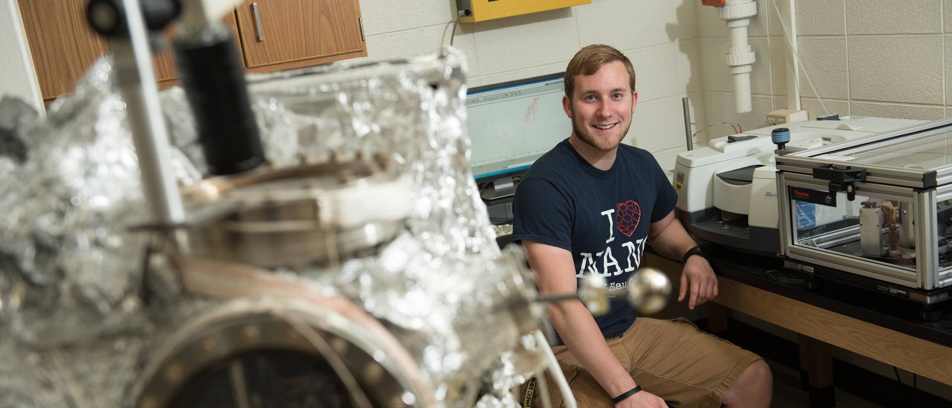 Kyle Lobermeier sits in a materials science lab and smiles.