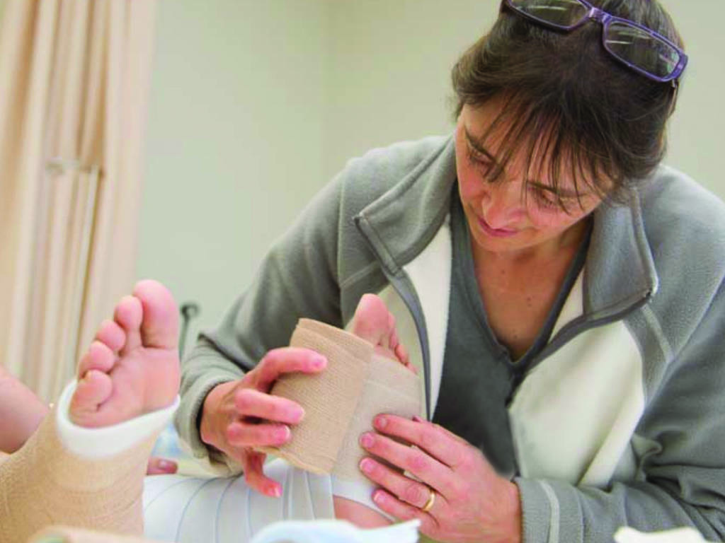 A nurse practices wrapping a foot as part of the Wound Treatment Associate clinical