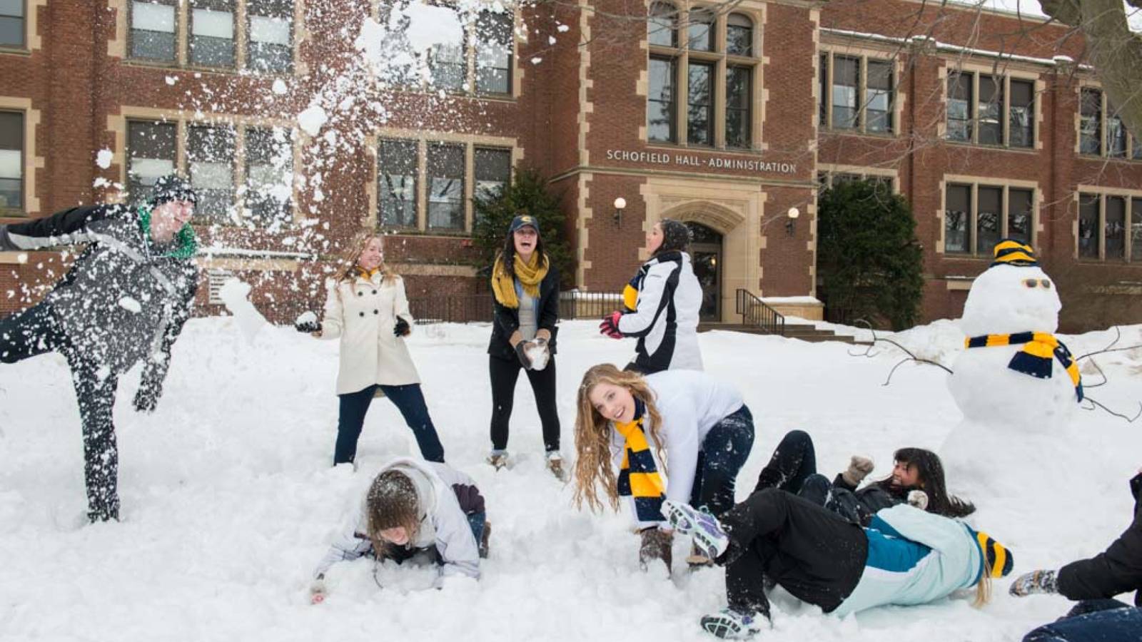 Students having snow fight in front of Schofield Hall