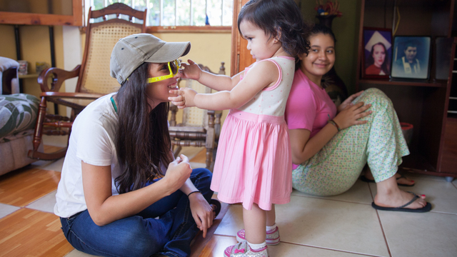 Student and little girl playing with sunglasses