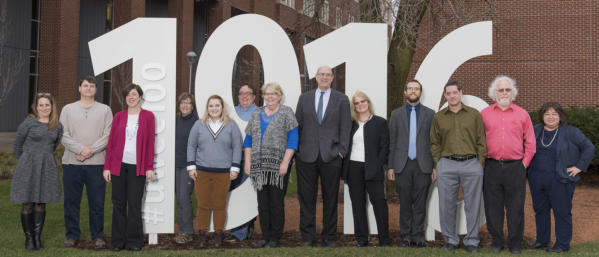 History faculty stand next to 1916 centennial sign