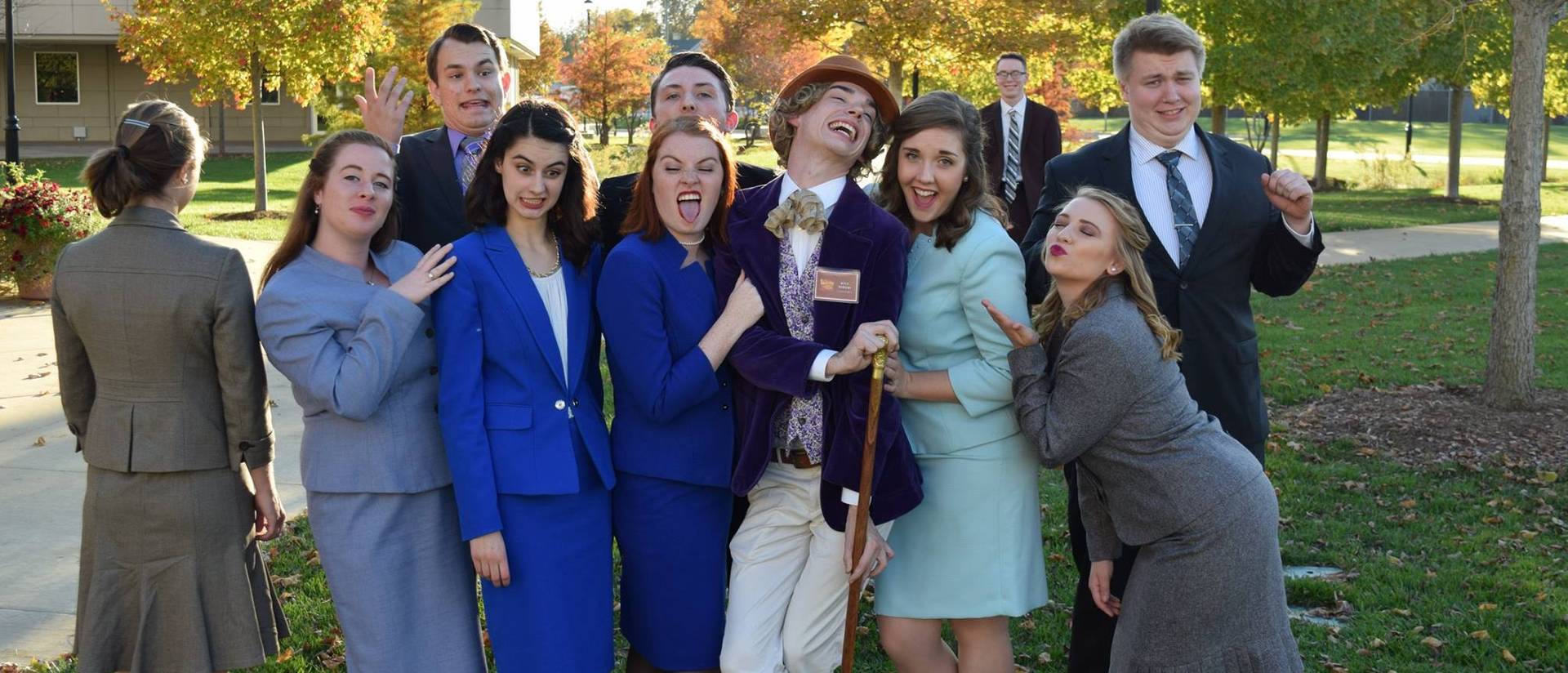 Forensics students make funny faces as they surround a student dressed as Willy Wonka.