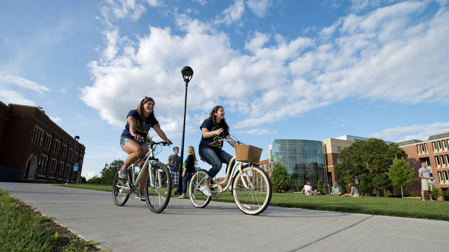 Students riding their bikes on campus.