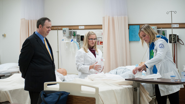 Patient in bed surrounded by nurses.