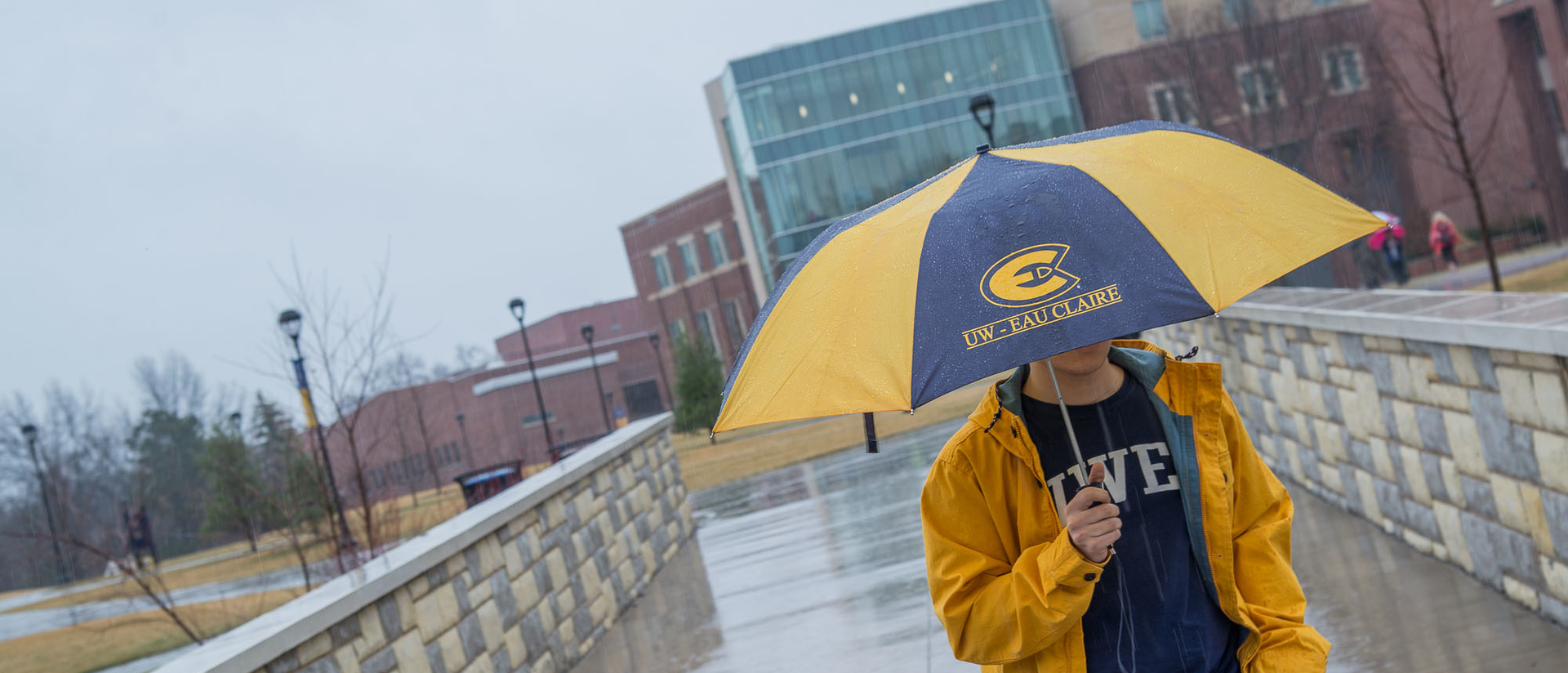 Student in the rain at UWEC