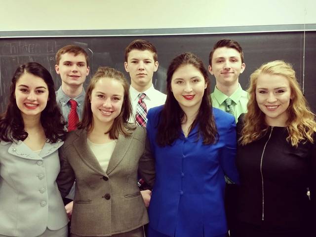 Professionally dressed Forensics students pose for a group picture.