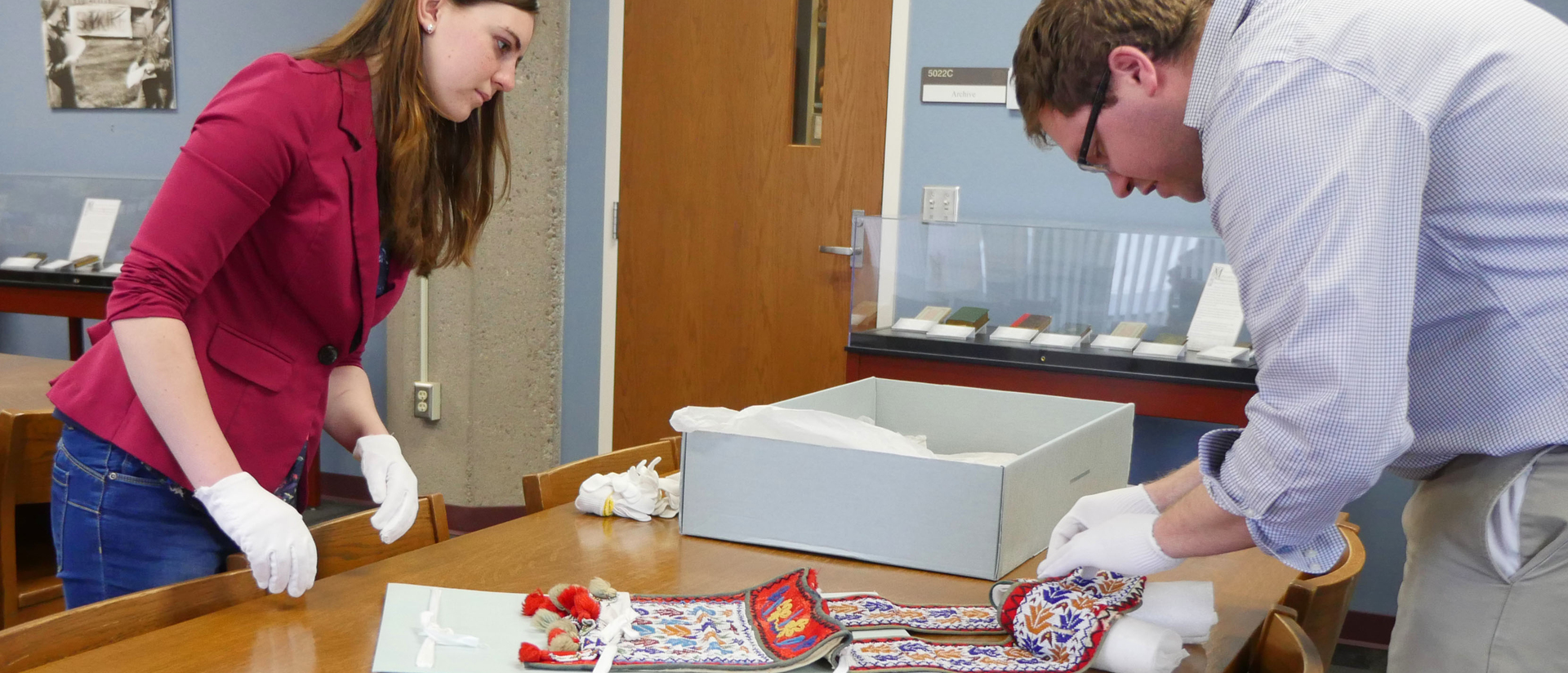 Shelby Miller examining Indian artifact in McIntyre archives. 