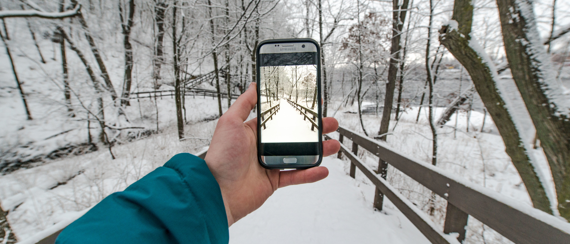 Student holds photo to take a picture in the winter.