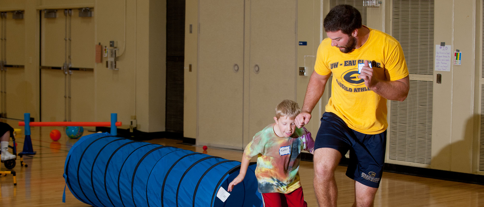 Student teacher helping boy get active.