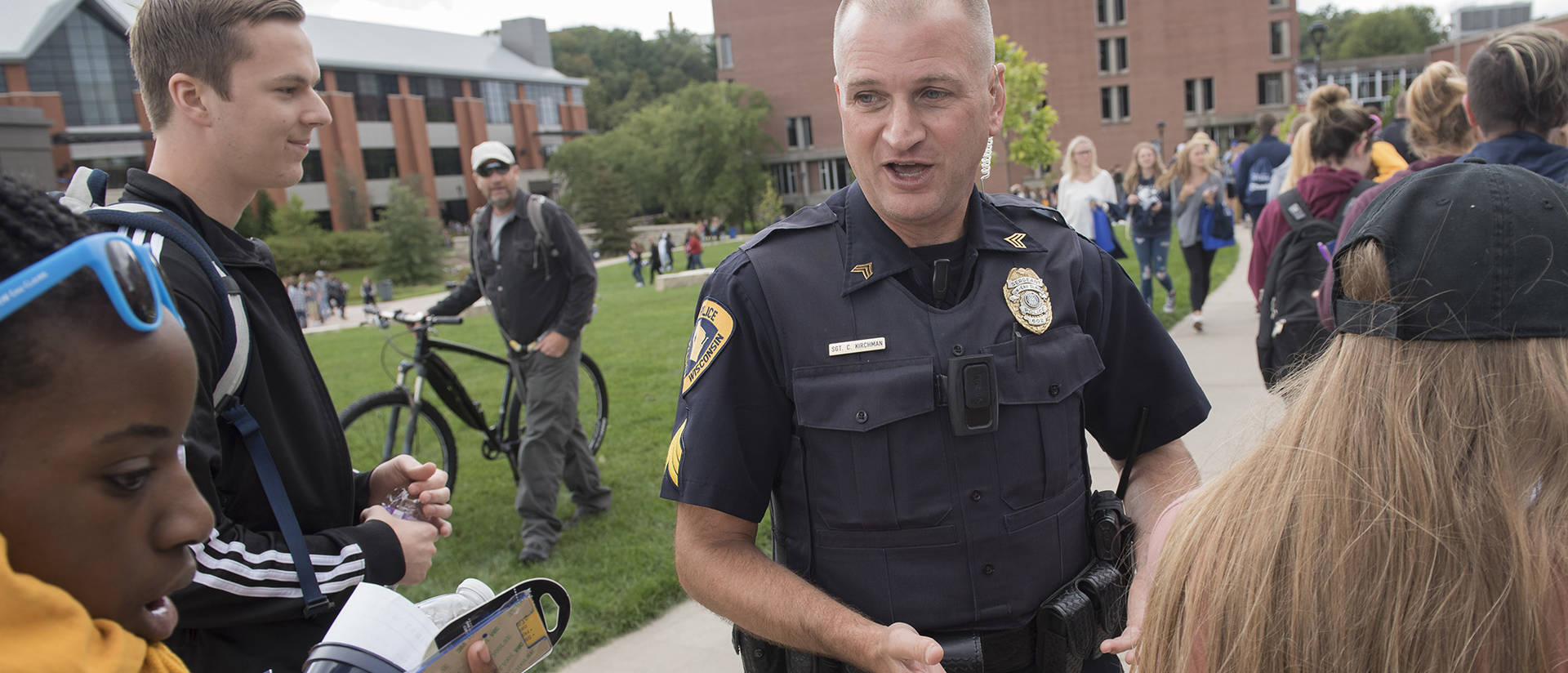 Campus police officer talking to new students on day one. 