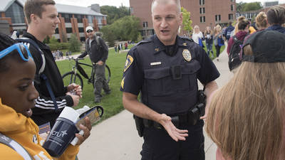 Campus police officer talking to new students on day one. 
