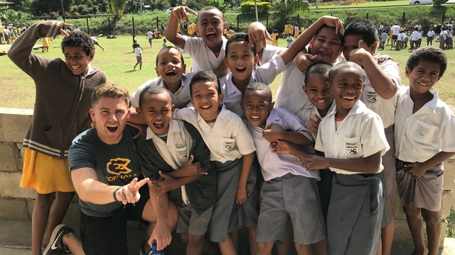 UWEC student poses with Fiji school children