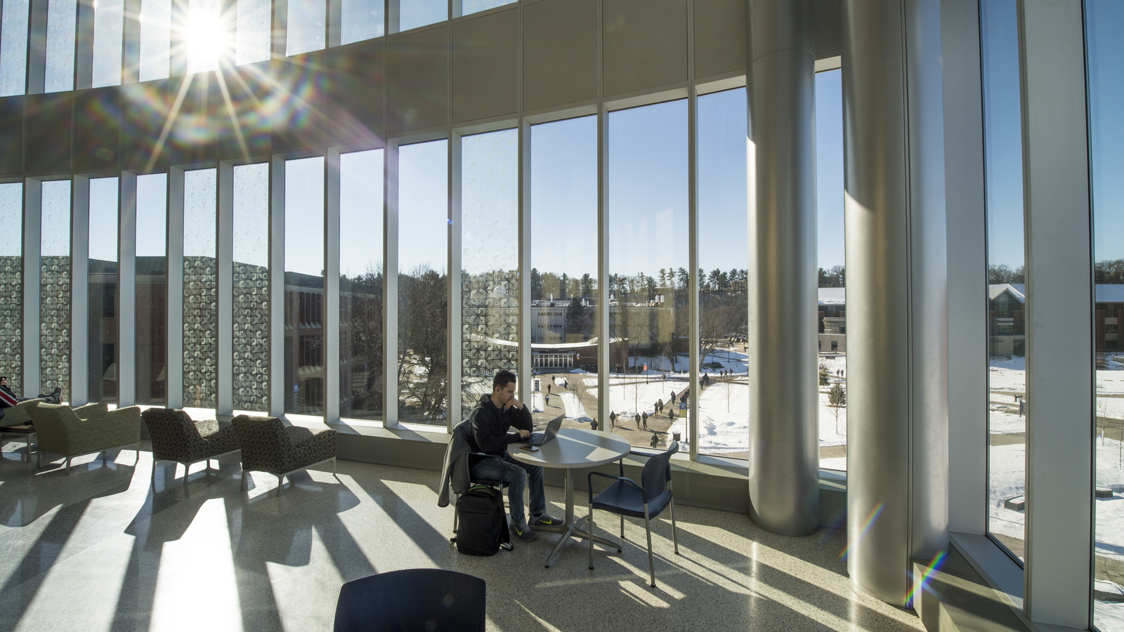 Student studying in sunny windows of Centennial Hall during winter
