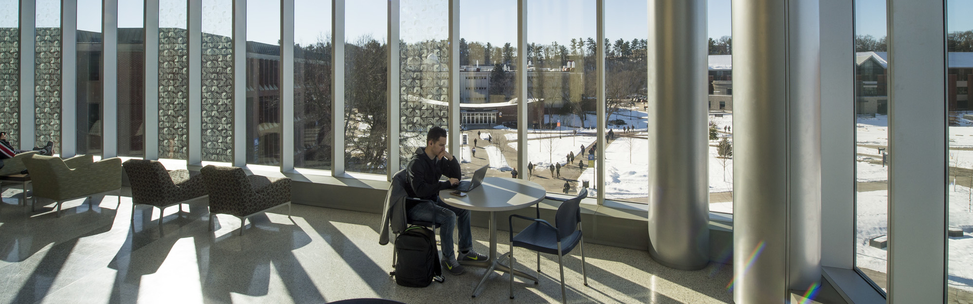 Student studying in sunny windows of Centennial Hall during winter