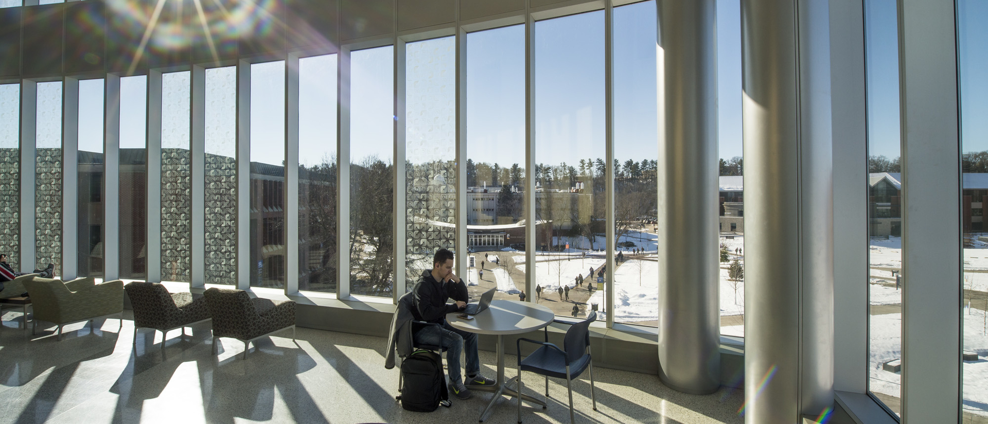 Student studying in sunny windows of Centennial Hall during winter