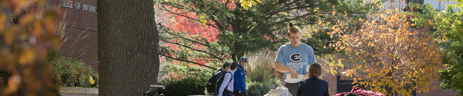 Students outside Schofield by bench in the fall