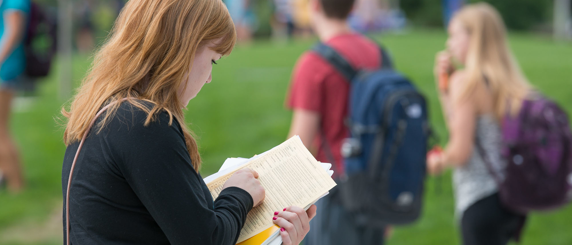 Student walking and reading papers