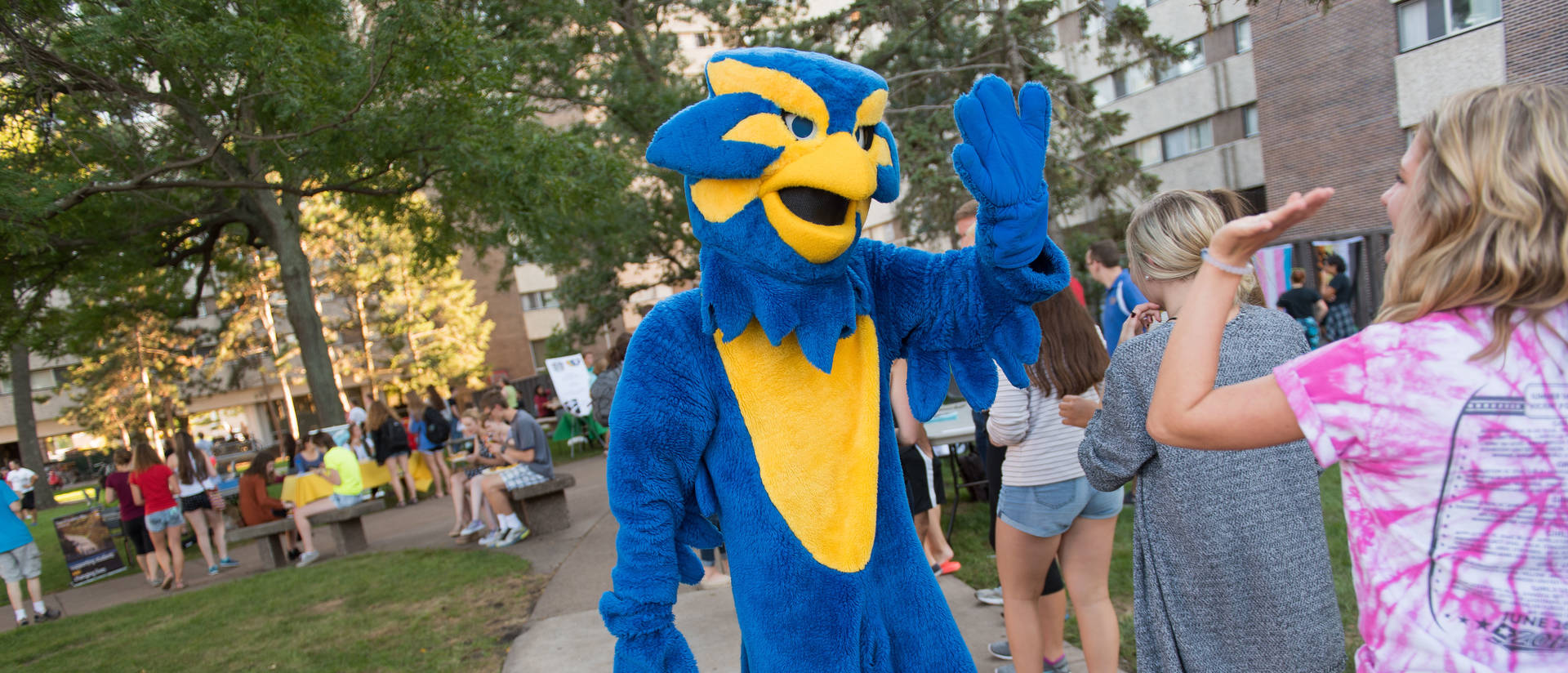 UWEC Mascot Blu high-fiving students at cookout