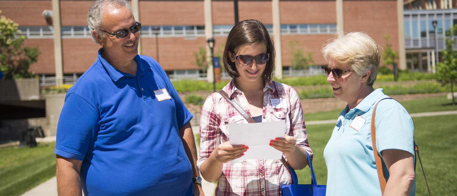 Parents and student on cmapus for orientation, outside on campus mall. 