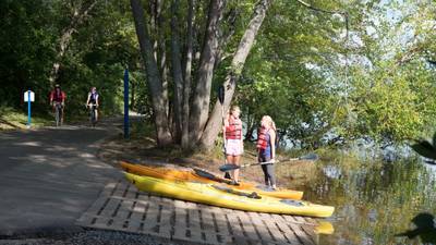 Students using rented kayaks, entering Chippewa River on the bike trail near campus. 
