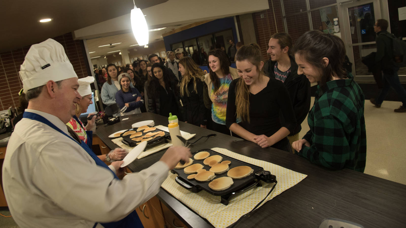 Chancellor Jim Schmidt flips pancakes for hungry students during finals week.