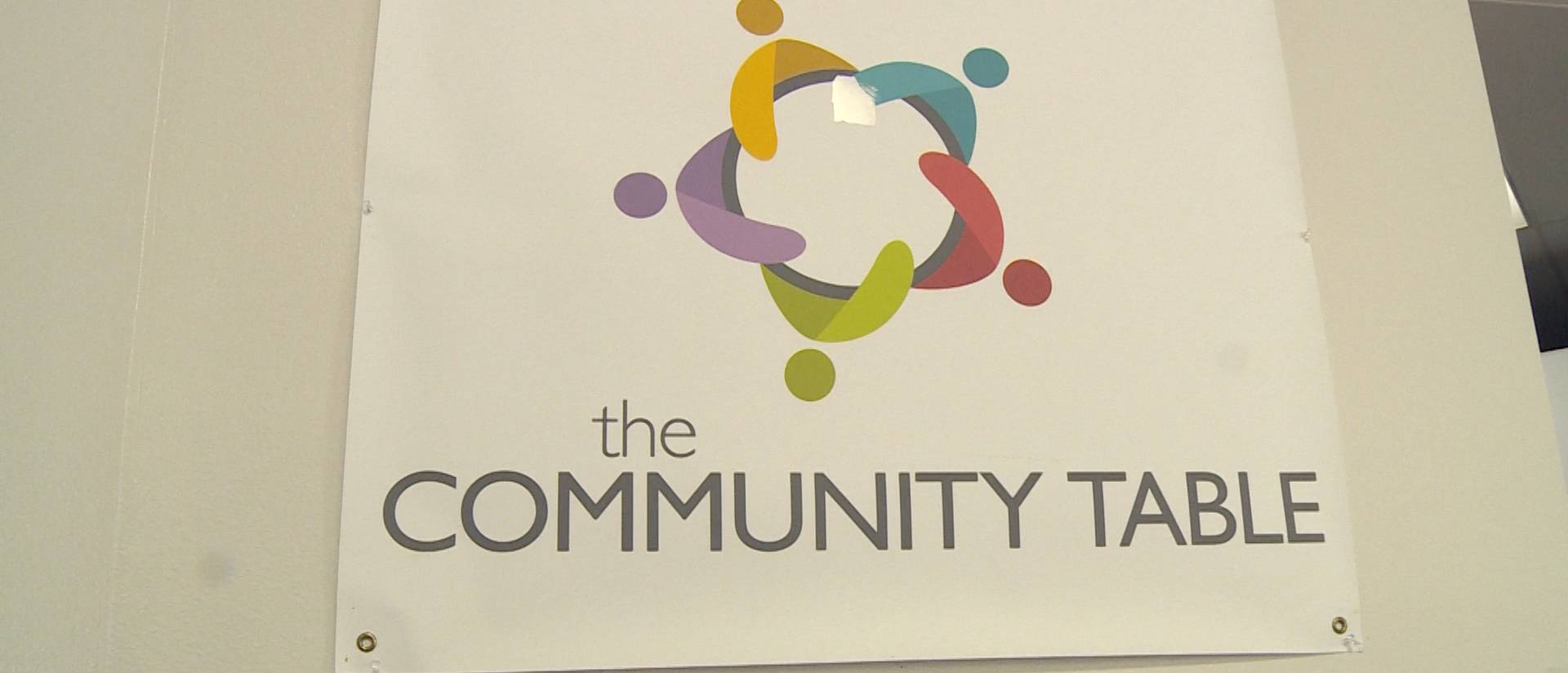 A poster for The Community Table hangs on a wall.