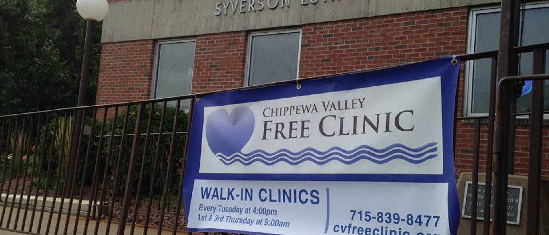 A Chippewa Valley Free Clinic banner hangs from a railing.