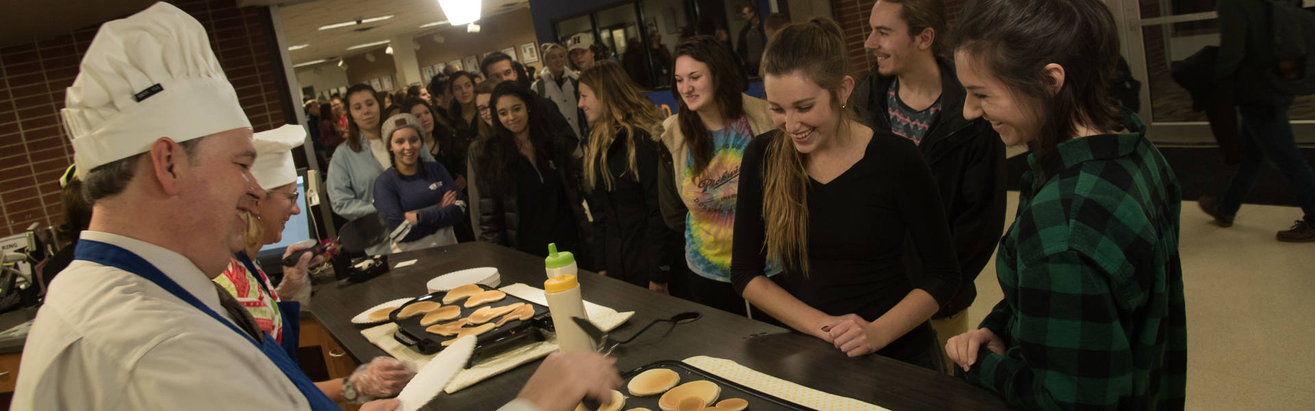 Chancellor Jim flips pancakes in the library for finals week. 