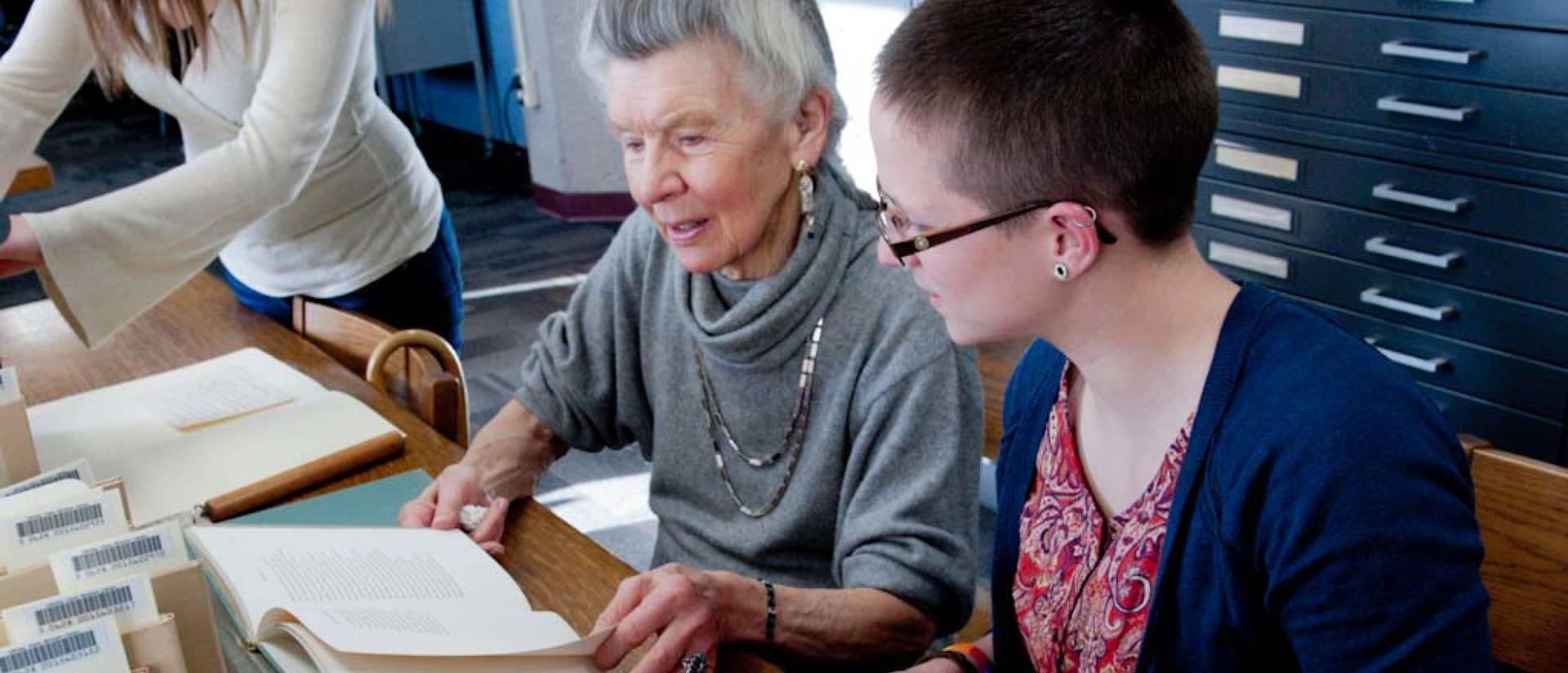 The donor and UW-Eau Claire staff and students examine the Robert Frost Collection.