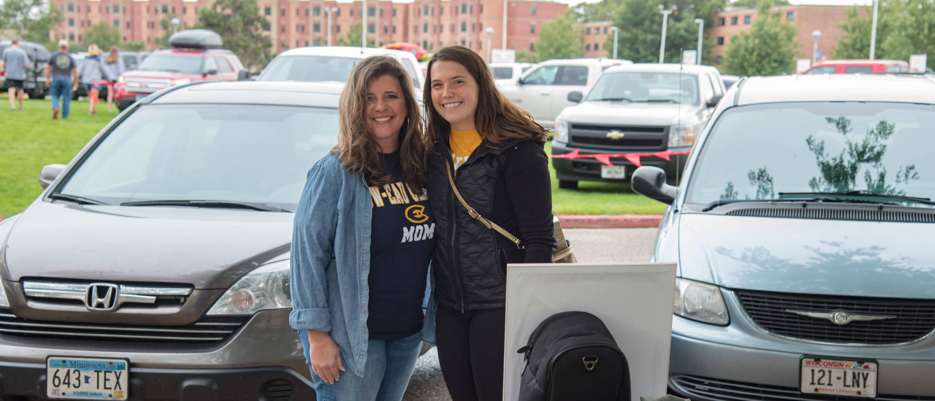 Blugold mom and student standing outside near residence hall