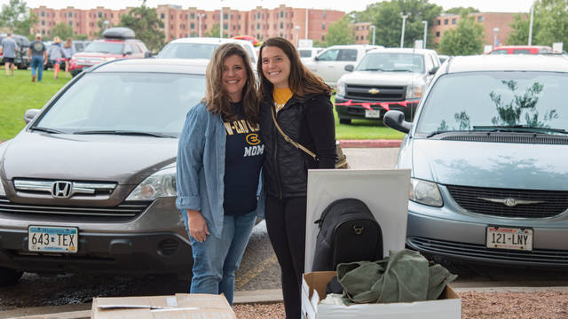 Blugold mom and student standing outside near residence hall