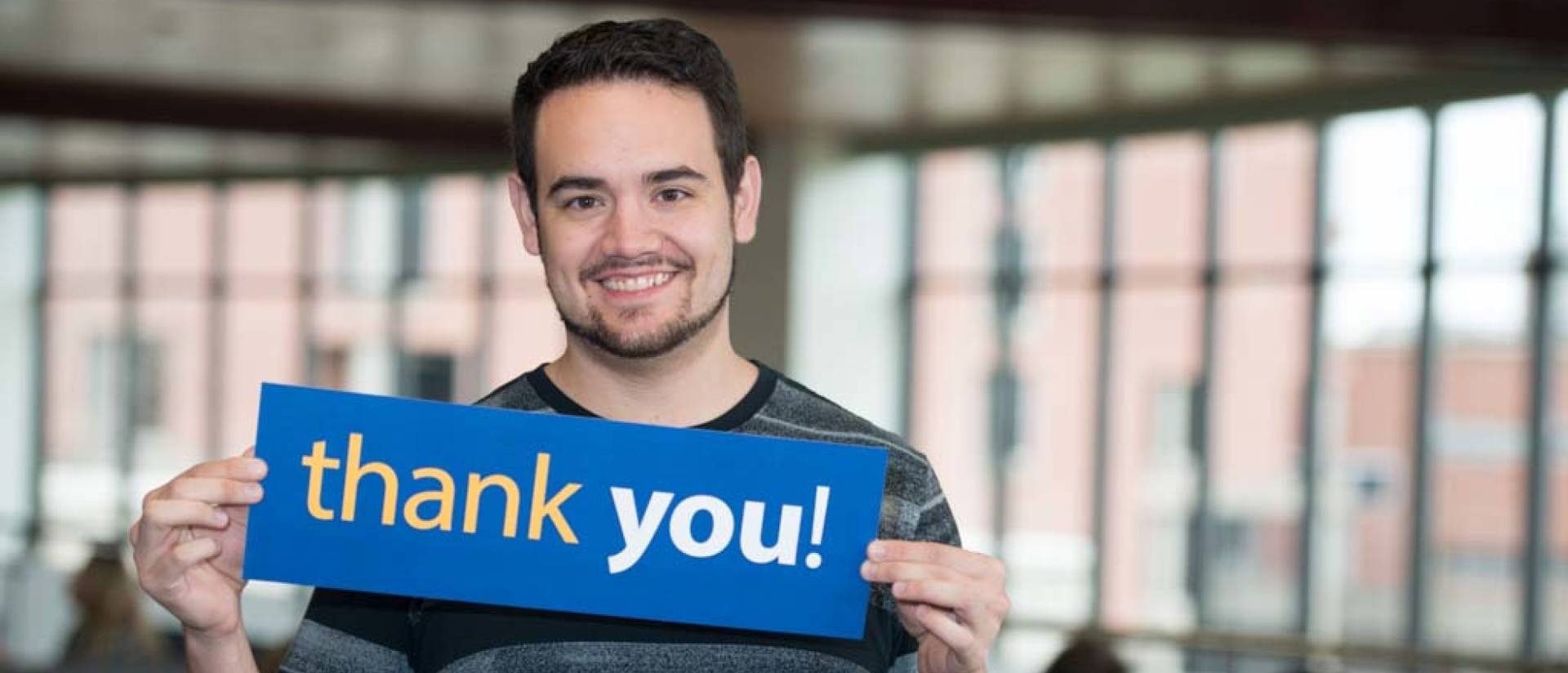 UWEC student Brendon Hernandez holds Thank You sign